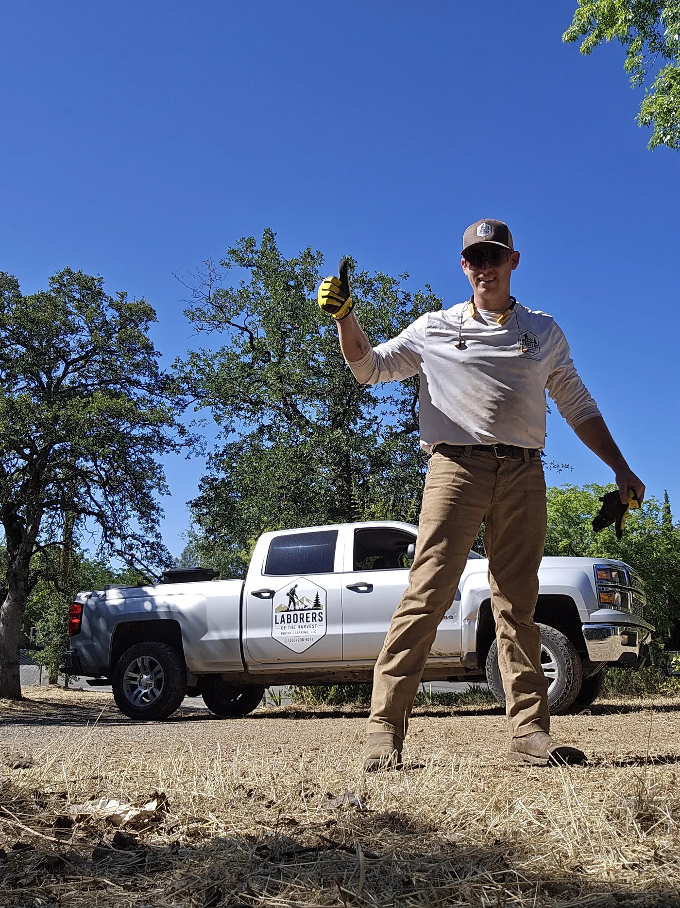 Grant Hatfield of Laborers of the Harvest beside the company truck on a cleared lot